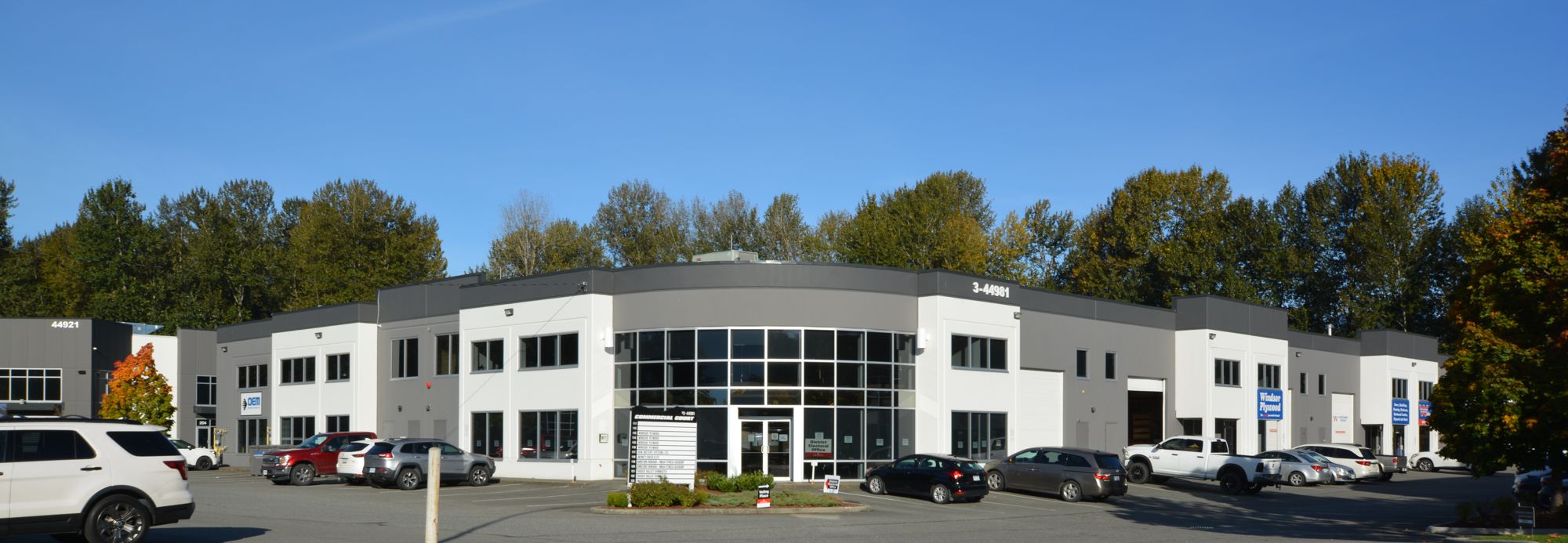 Front of 44981 Commercial Court, a two-storey white and grey commercial building with a curved glass entrance
