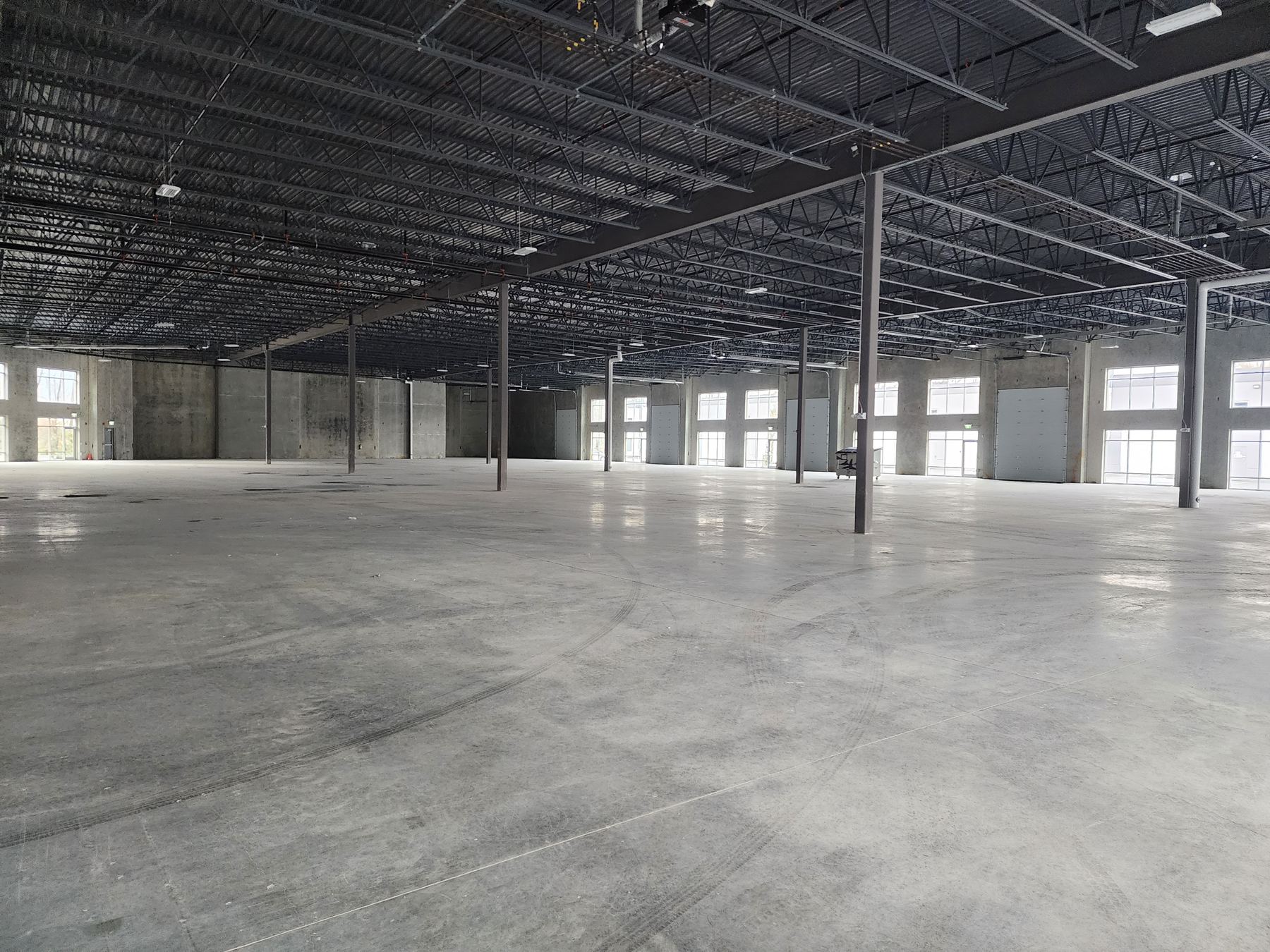 Interior of a new warehouse unit at Commercial Court Chilliwack showing 24 foot clear height, steel trusses and grade level overhead doors