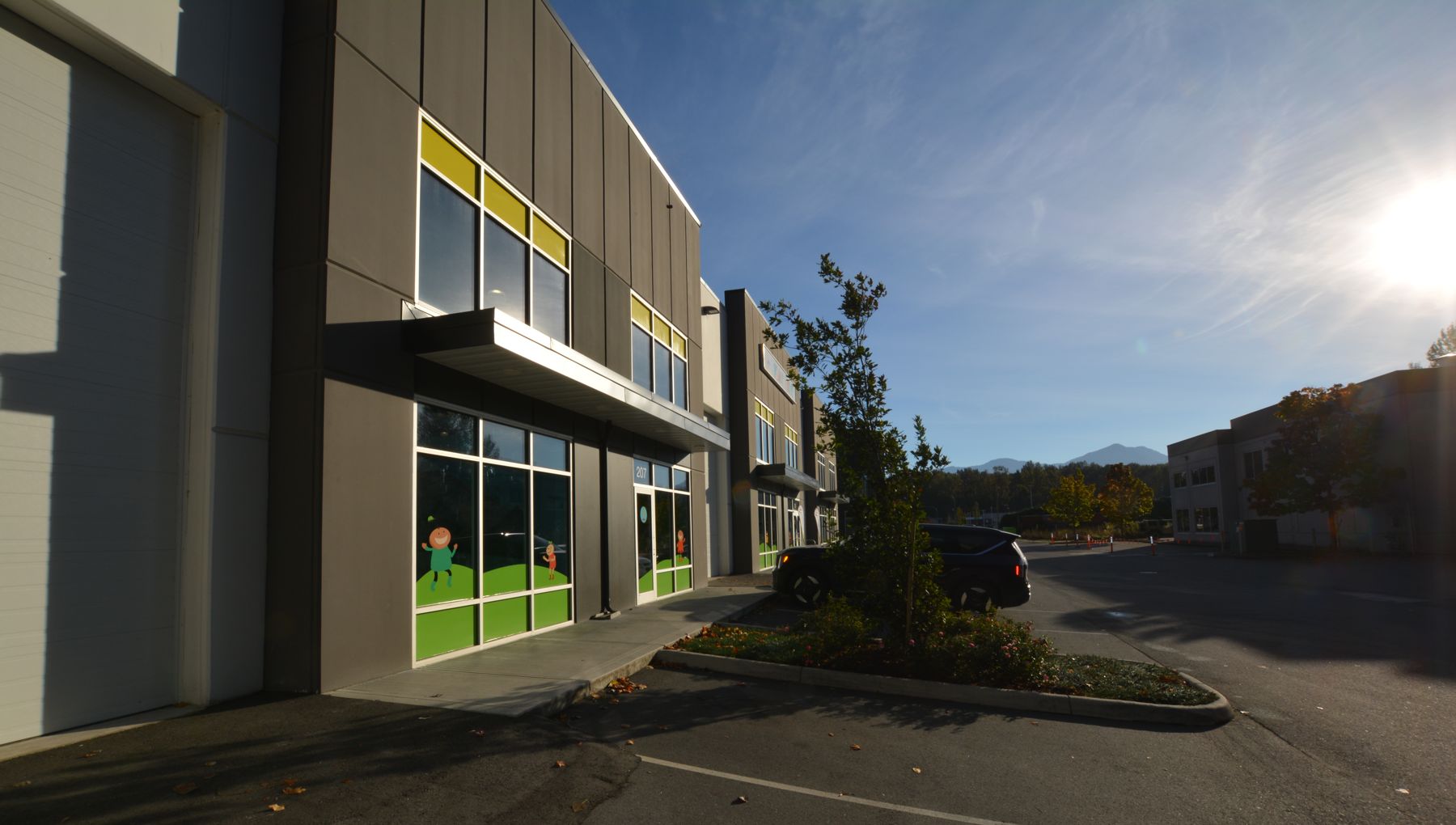 Grade-level overhead door beside a glazed storefront on the 44921 Commercial Court building in Chilliwack